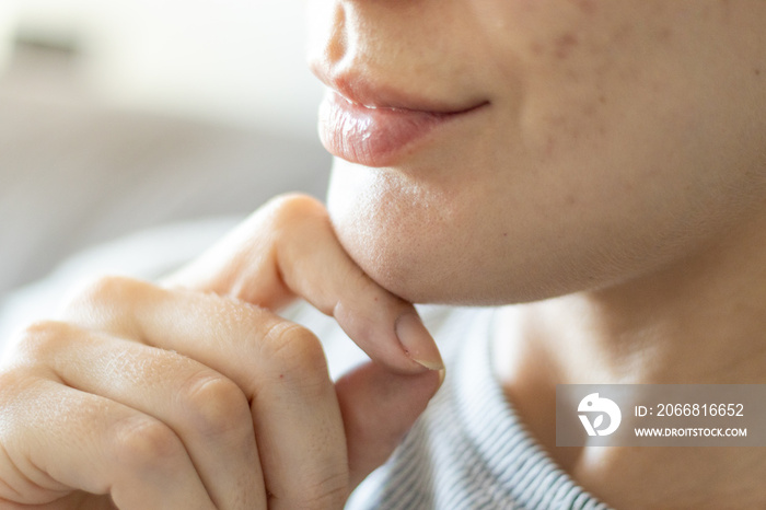 closeup of a woman’s face with skin imperfections, Causasian, Brazilian, smile and hand, natural.