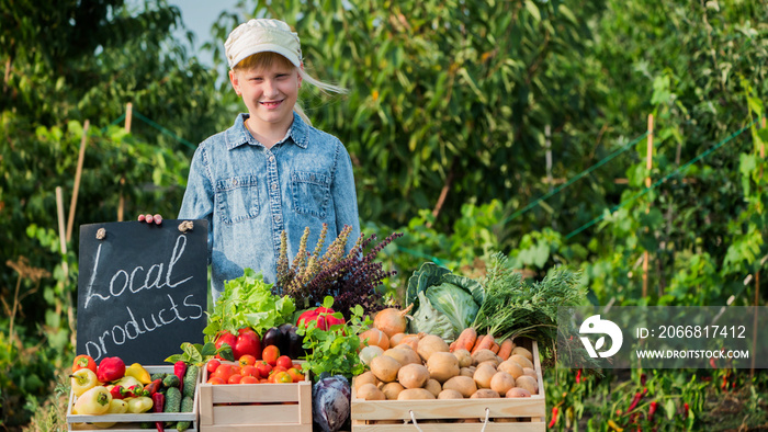 Little farmer girl at the counter with vegetables