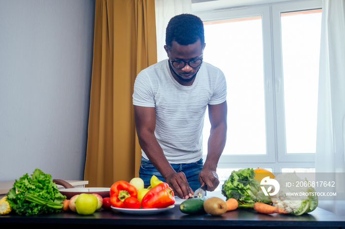 afro male hamds cutting apple,eggplant and kivi