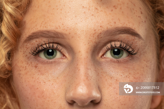 Beautiful young woman’s eyes close-up shot. Female model with well-kept skin. Perfect skincare, human emotions, facial expression, beauty and cosmetics concept. Deep green color and eyebrows.