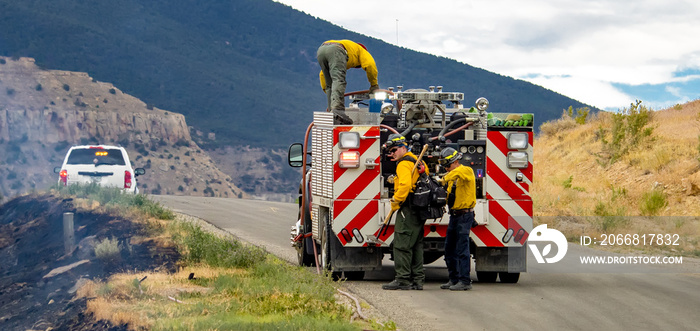 Firefighters battle a wildfire from a brush engine