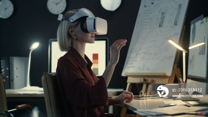 Modern business woman wearing virtual reality glasses in night office