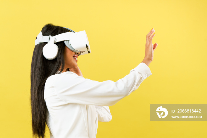 Black Asian woman wearing VR headset over yellow background to get excite experience of virtual reality technology, Digital 3d simulation entertainment at home, VR Simulator for Education concept.