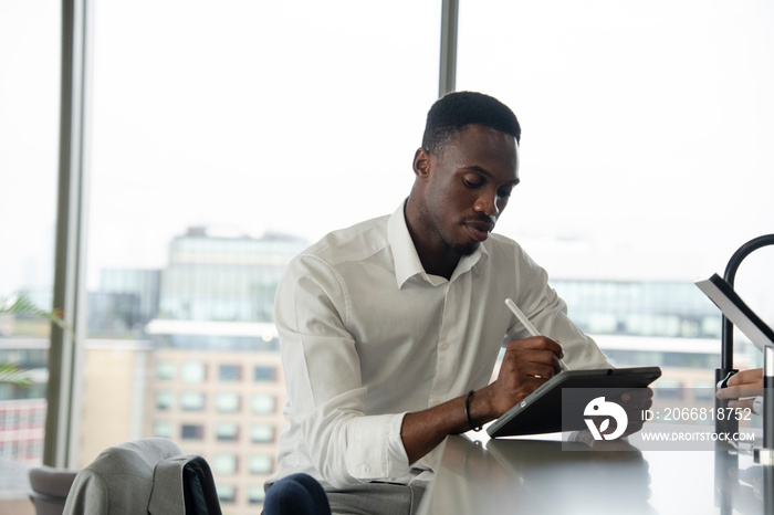 Young businessman using digital tablet in office