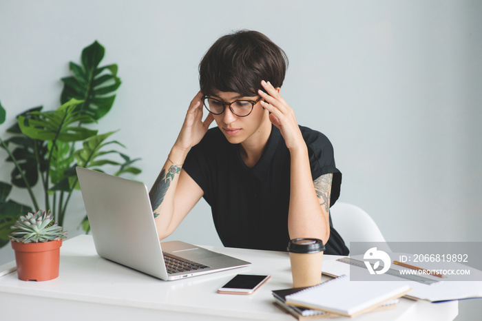 Tired businesswoman in glasses at workplace in office.