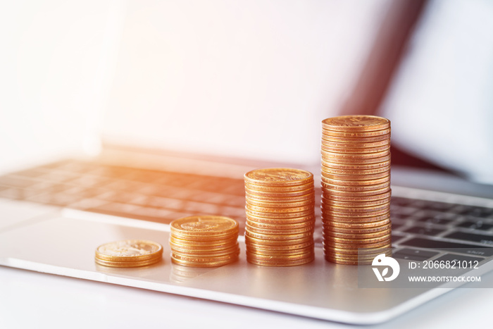 stack of money coins on laptop computer background