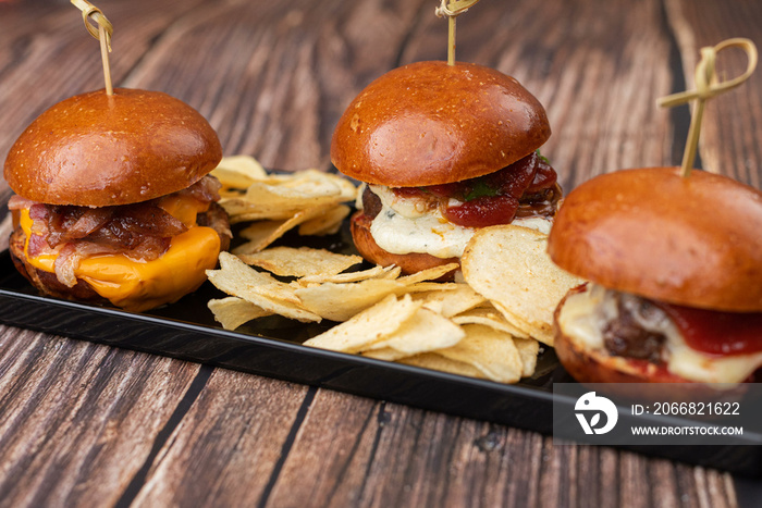 three mini hamburgers with potato chips