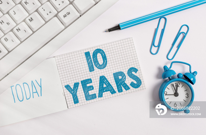 Writing note showing 10 Years. Business concept for Remembering or honoring special day for being 10 years in existence White pc keyboard with paper and paper clip above white background