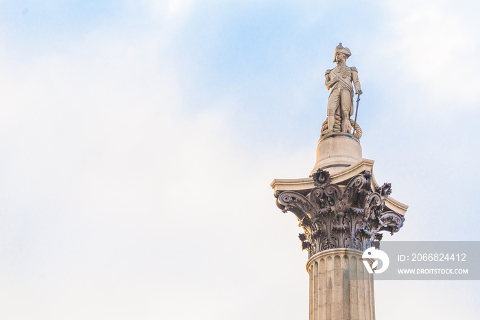 Famous statue of Admiral Nelson on Trafalgar Square in London, UK, on blue clear sky.