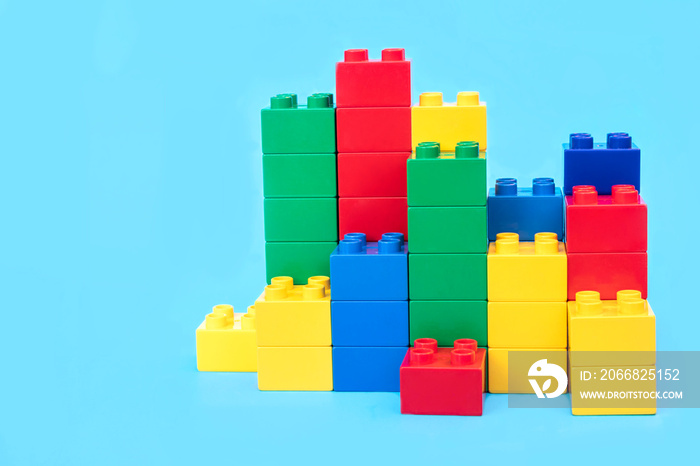 Bar graphs plastic building blocks toy bricks on blue background.