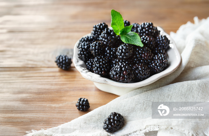 Freah blackberries in bowl and leaves closeup