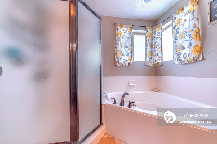 Bathroom built in bathtub and shower stall with framed frosted glass enclosure