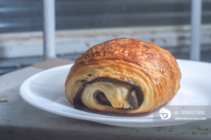 Pain au Chocolat on a white dish with natural light  chocolate bread  with foled dough