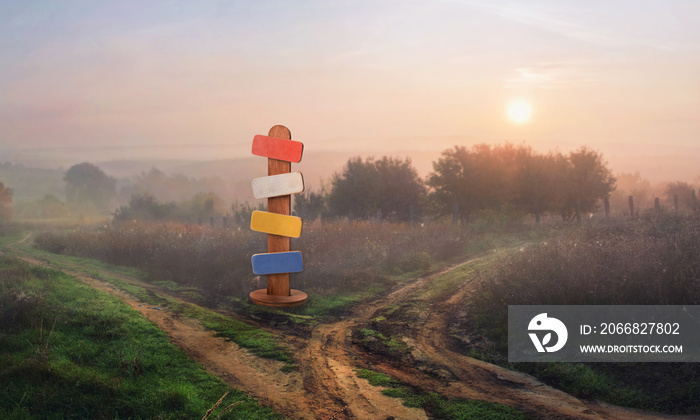 Signpost on a country road at sunset