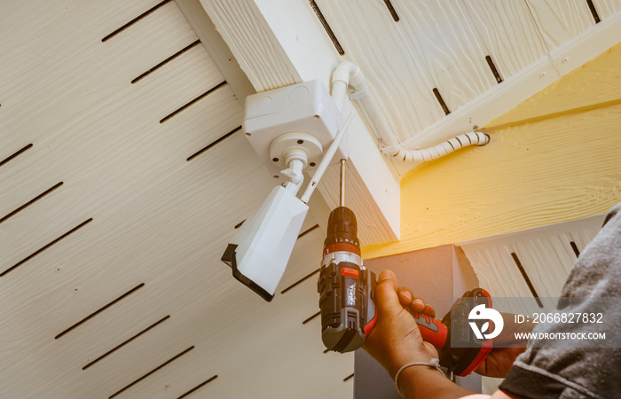 Technician installing wireless CCTV camera system on the building wall