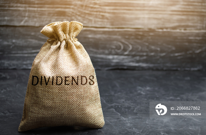 Money bag with the word Dividends. A dividend is a payment made by a corporation to its shareholders as a distribution of profits. Concept business finance and investment. Saving money. Dividend tax