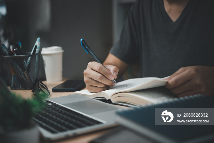 man hands with pen writing on notebook in the office.learning, education and work.writes goals, plans, make to do and wish list on desk.