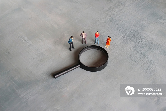 Concept of frequently asked questions, query, investigation, search for information. Miniature people looking at magnifying glass