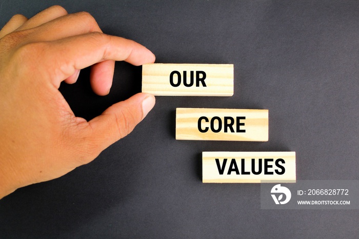 finger holding a stick with the words Our Core Values. the concept of core value or main value