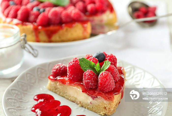 Plate with piece of delicious raspberry cheesecake on table