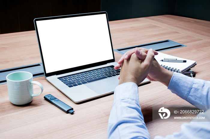 Businessman hands clasped together and white screen background mock up on display laptop with clipping path