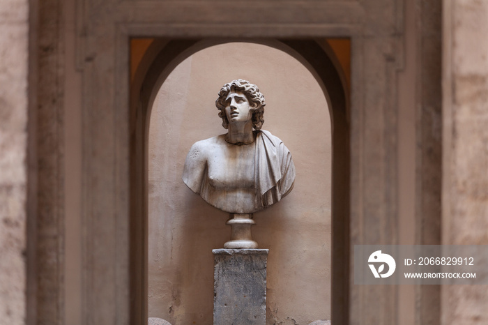 Sculpture of a male bust in a small courtyard