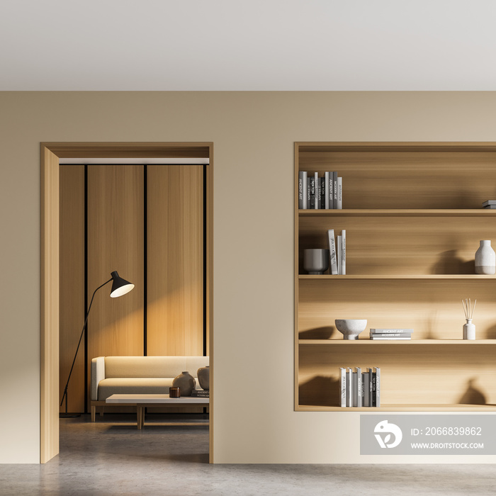 Beige living room interior with bookshelf and sofa behind door