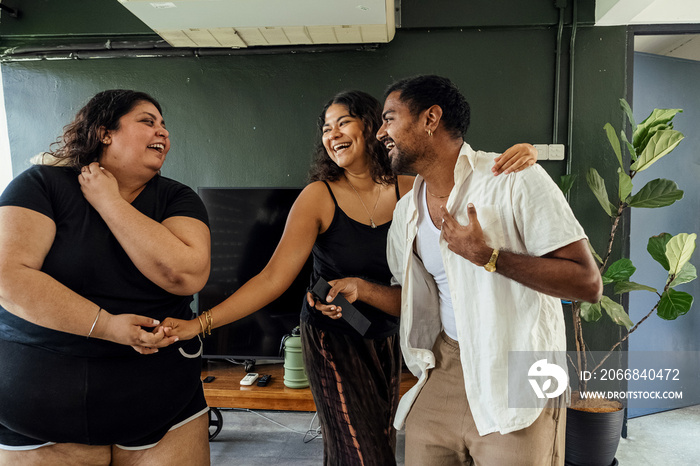 Friends dancing and singing together at home on a weekend