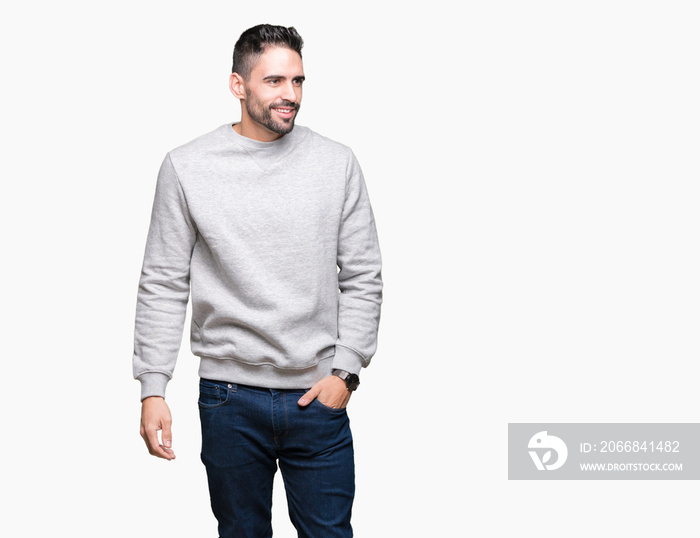 Young handsome man wearing sweatshirt over isolated background looking away to side with smile on face, natural expression. Laughing confident.