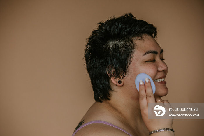 close up of plus size filipino woman practicing skincare