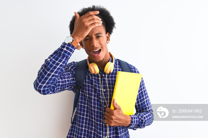 African american student man wearing headphones backpack over isolated white background stressed with hand on head, shocked with shame and surprise face, angry and frustrated. Fear and upset