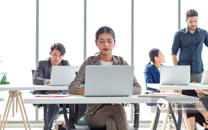 Asian stressed exhausted tired female businesswoman secretary working late and hard sitting at workplace in company take off glasses hold hand massaging painful shoulder from office syndrome symptom