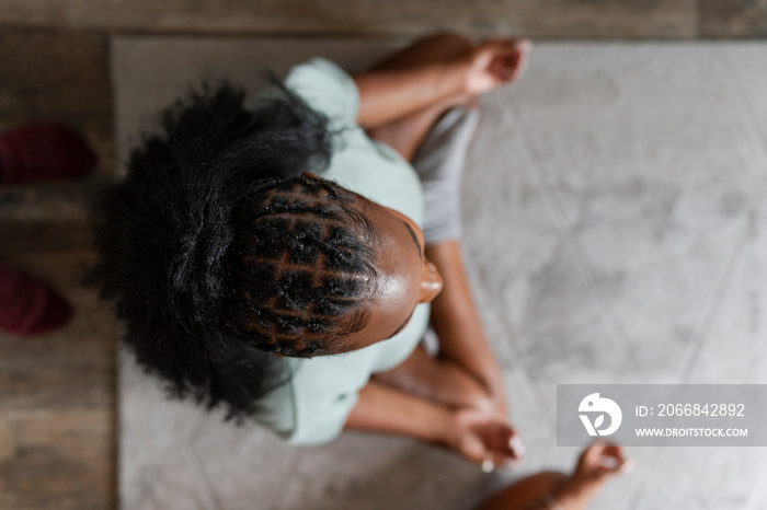 Directly above view young woman practicing yoga at home