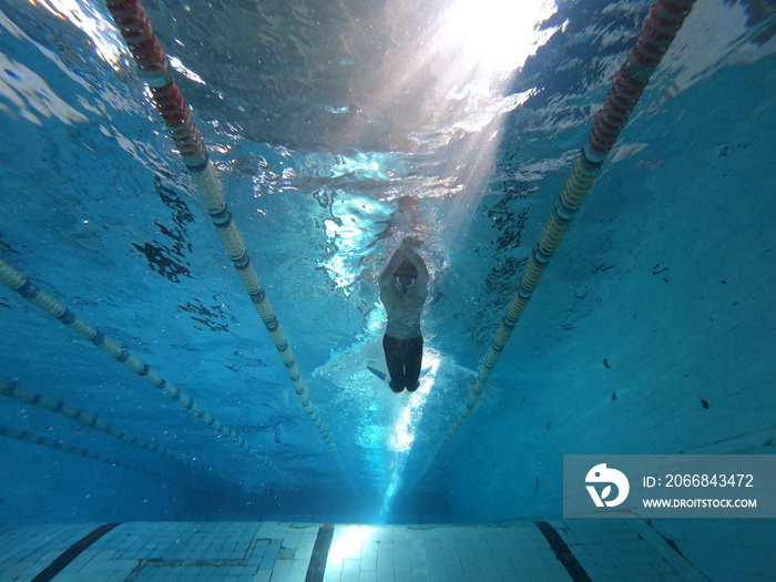 Young swimmer training inside the swimming pool