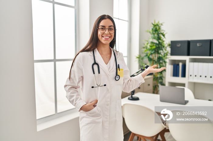 Young beautiful hispanic woman doctor smiling confident doing coming gesture with hand at clinic