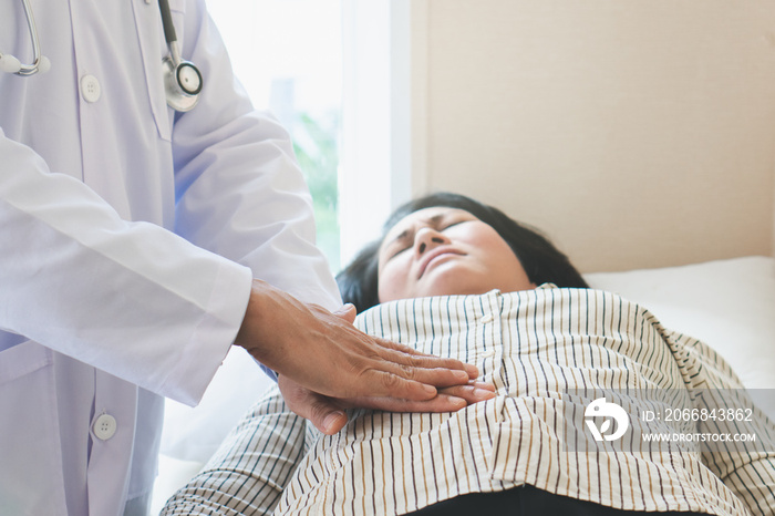 Doctor examining stomach of woman patient and pressing hands on her belly.