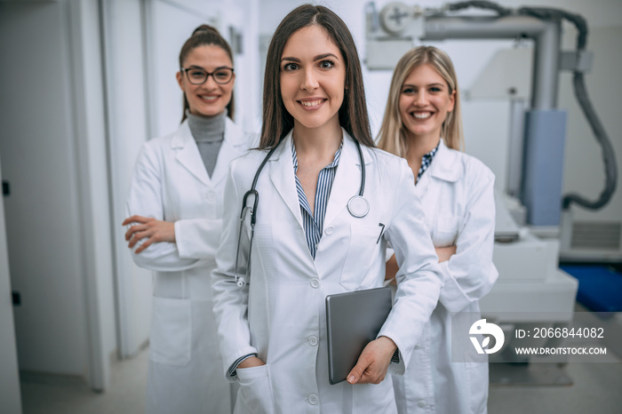 Smiling female doctor and nurses in hospital.