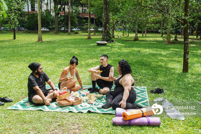 Group of friends enjoying a picnic together in the park