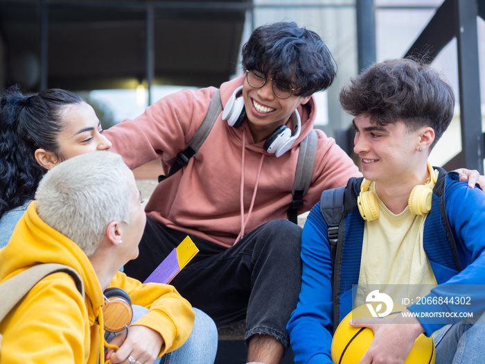 Teenage student friends smiling and talking on a campus. High School, having fun