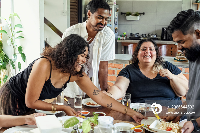 Group of friends sharing a meal together at home