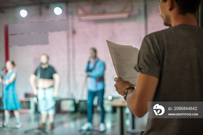 Behind the scene. Director of the play rehearses the play with the actors according to the script