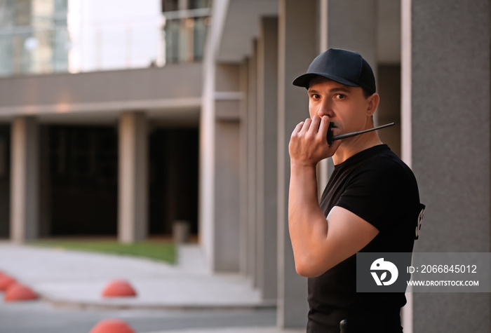 Male security guard with portable radio, outdoors