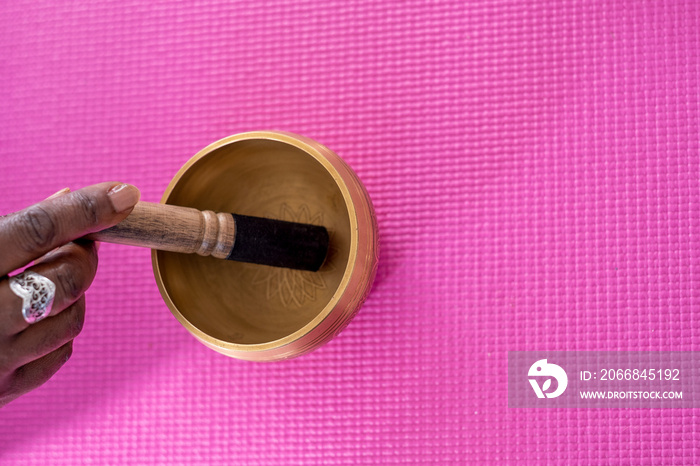 Close-up of woman’s hand using singing bowl in yoga studio
