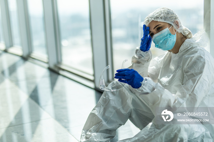 Nurse having headache and tired from work while wearing PPE suit for protect coronavirus disease. The wellbeing and emotional resilience are key components of maintaining essential care services.