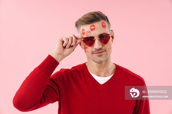 Portrait of man with kiss marks at his wearing heart-shaped sunglasses