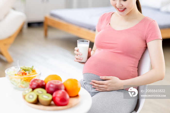 Asian pregnant woman drinking milk