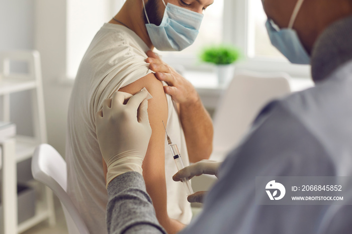 Patient in medical face mask getting antiviral vaccine during vaccination campaign