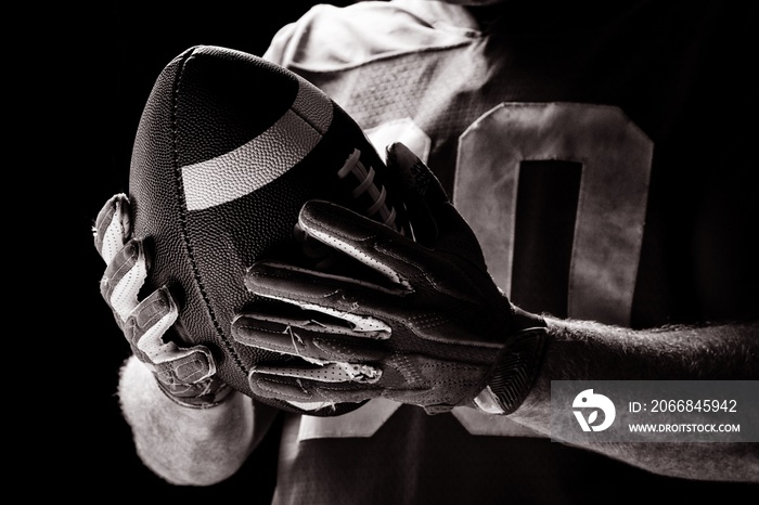 American football player holding rugby ball