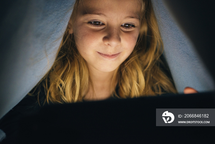 Sweet blondie girl playing on a Tablet.