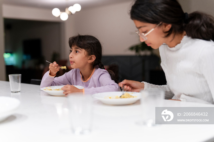 Sisters eating meal at table